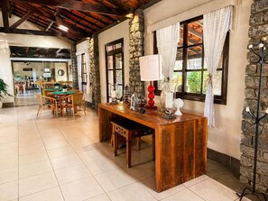 A dining area with a wooden table, chairs, and a stone wall.