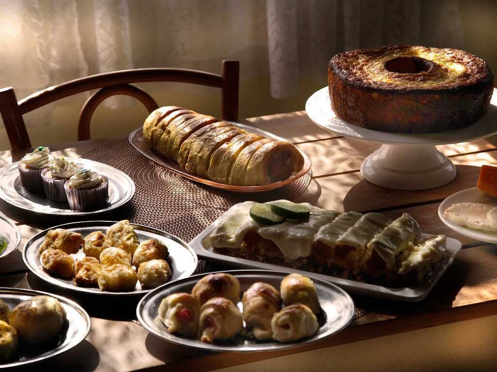A table with various baked goods including a loaf of bread, pastries, and a bundt cake.