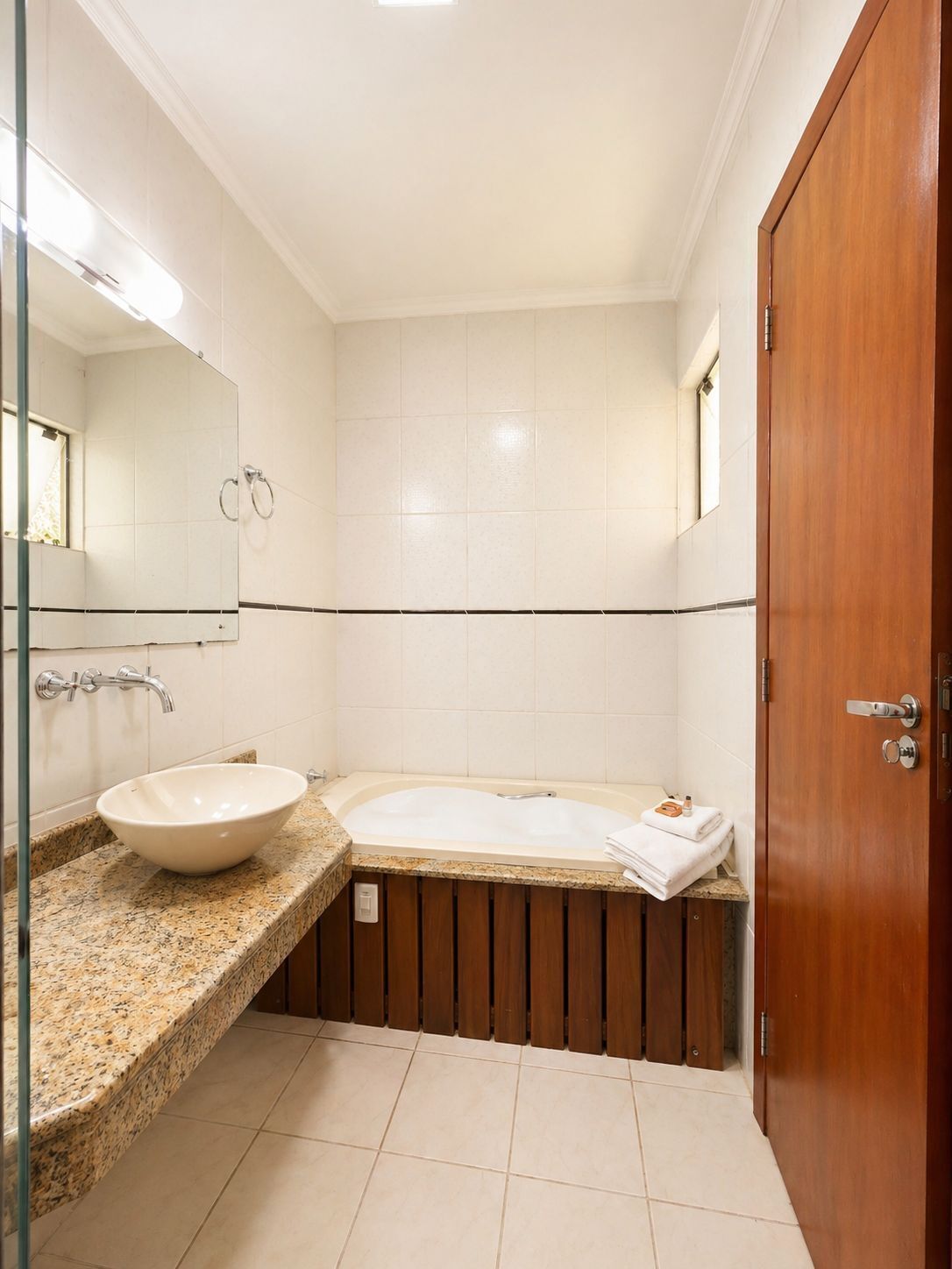 A bathroom with a sink, mirror, and bathtub.