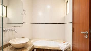A bathroom with a sink, mirror, and bathtub.