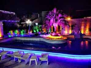 An outdoor pool area with lounge chairs and a central water feature. - Hotel Termal Rio Hondo (Termas de Rio Hondo)