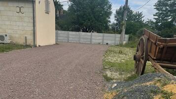 Un camino de grava que conduce a un edificio con fachada de piedra y una ventana pequeña.