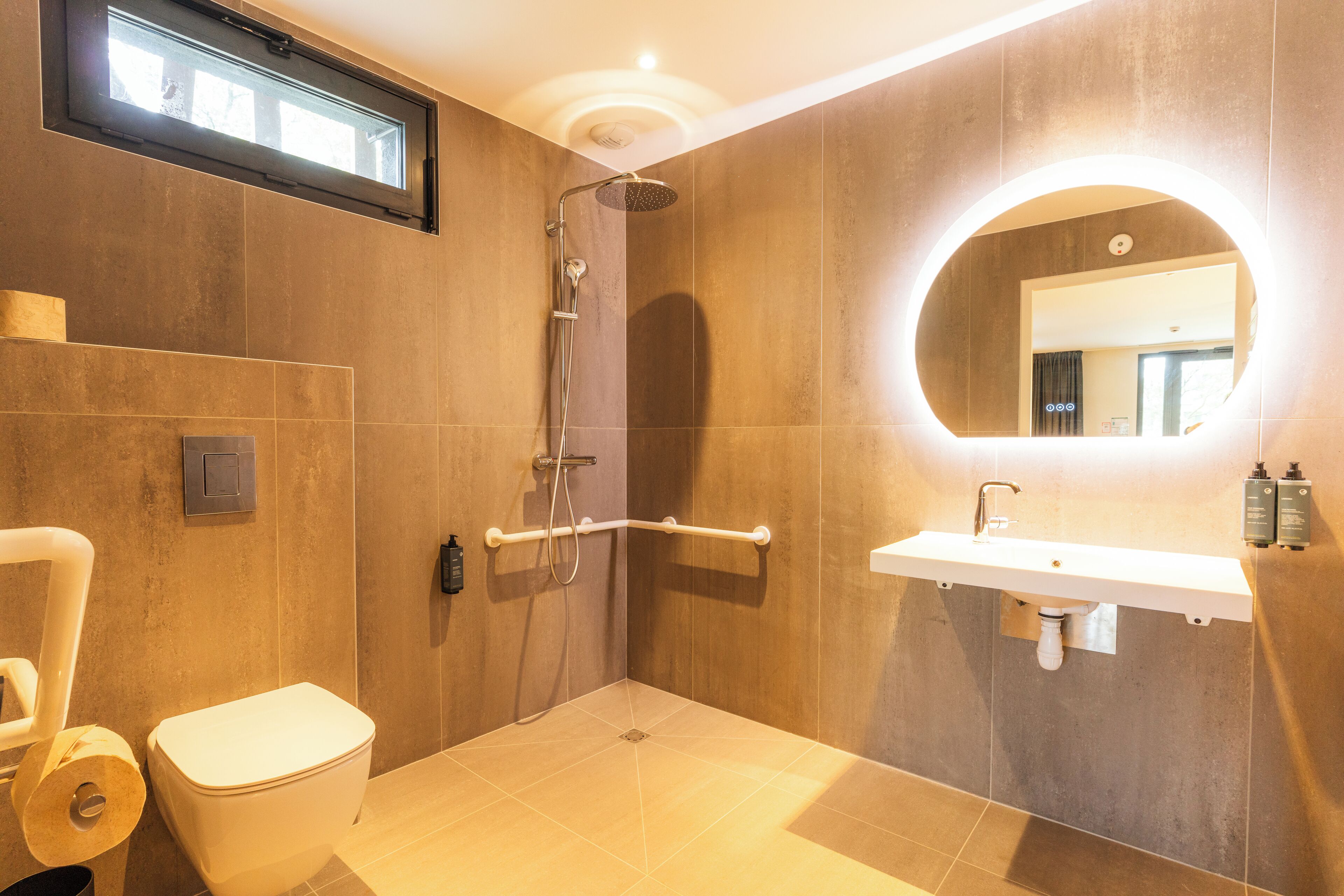 Une salle de bain moderne équipée d’une douche, de toilettes et d’un lavabo.