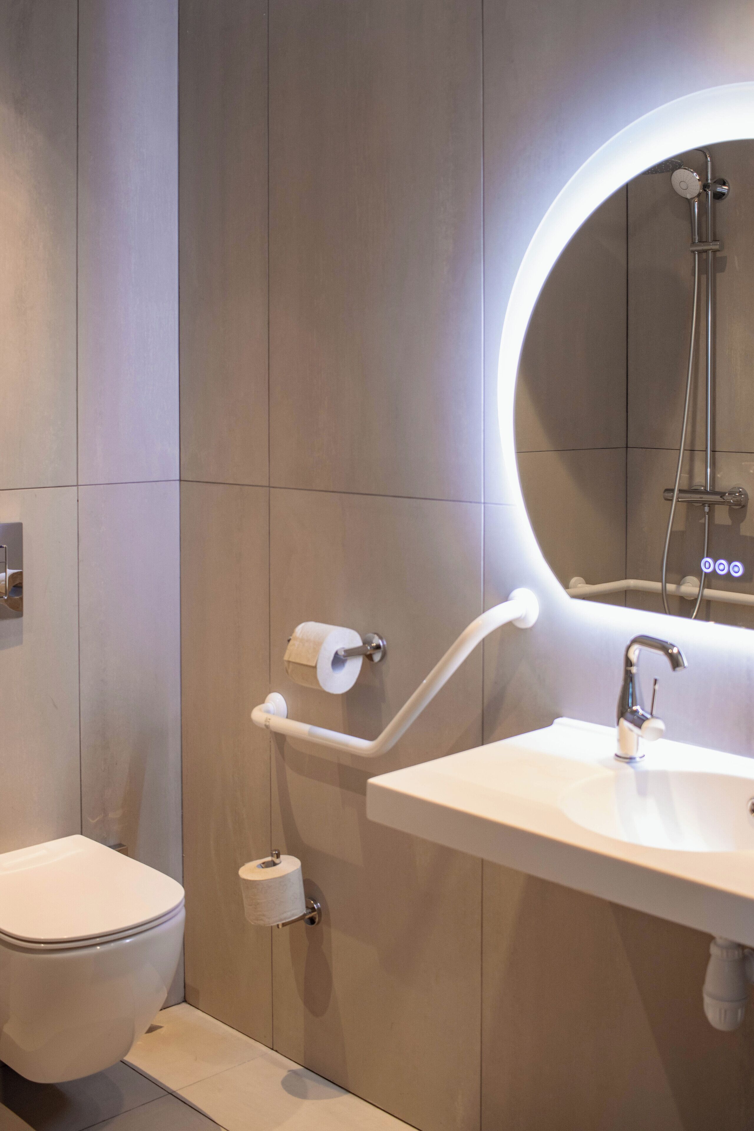 Un baño moderno con inodoro, lavabo y ducha.