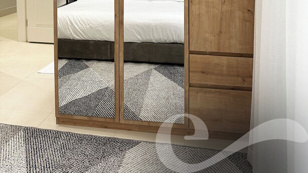 Ein Schlafzimmer mit großem Kleiderschrank, einem Bett und einer Klimaanlage.