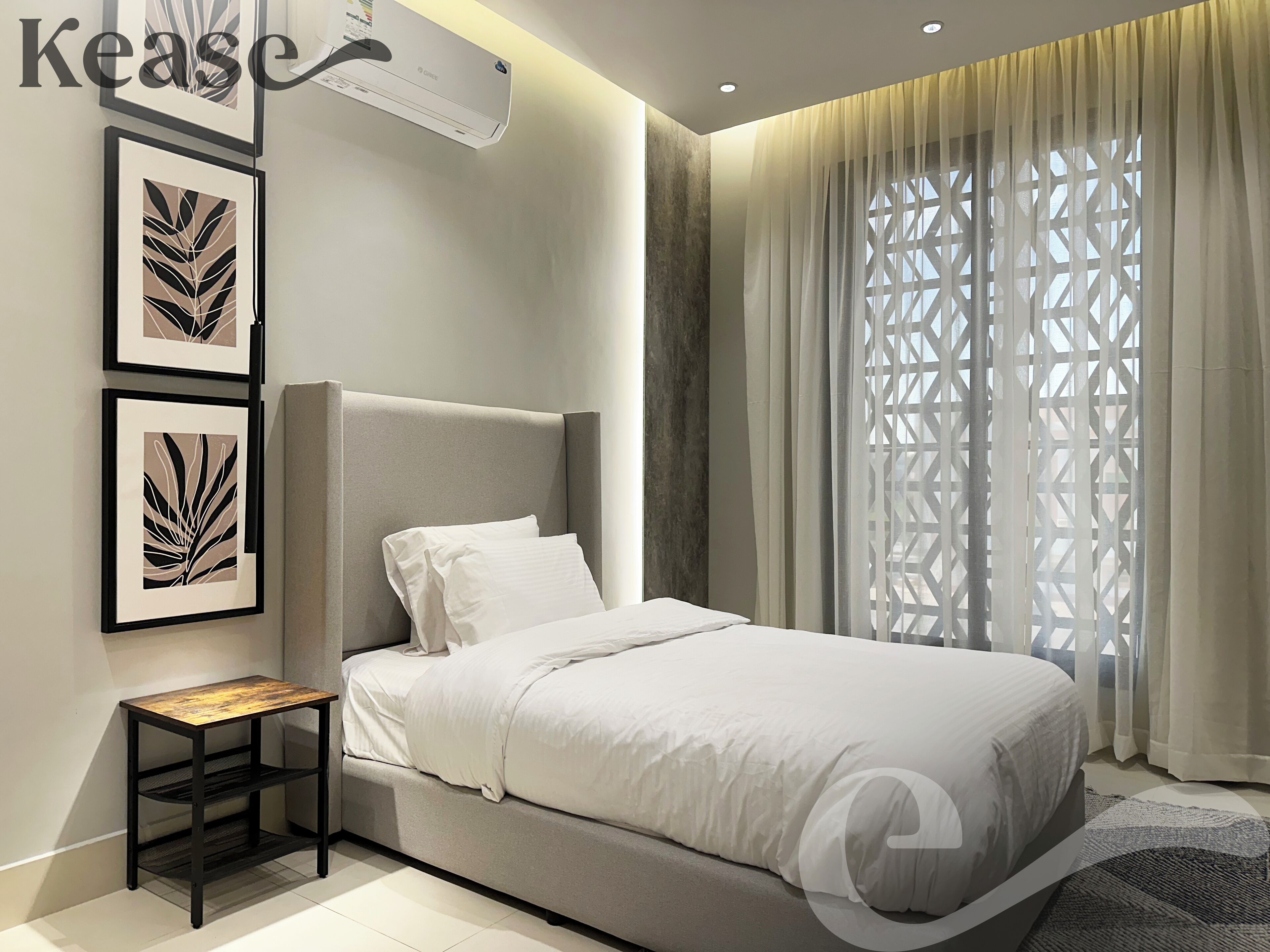 Un dormitorio moderno con una cama, una mesita de noche y una obra de arte en la pared.