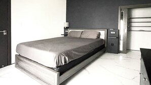 Une chambre à coucher moderne, avec un lit, des tables de chevet et une armoire.