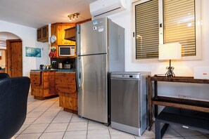 Une cuisine équipée d’un réfrigérateur en acier inoxydable, de meubles en bois, d’un four à micro-ondes et d’un lave-vaisselle.