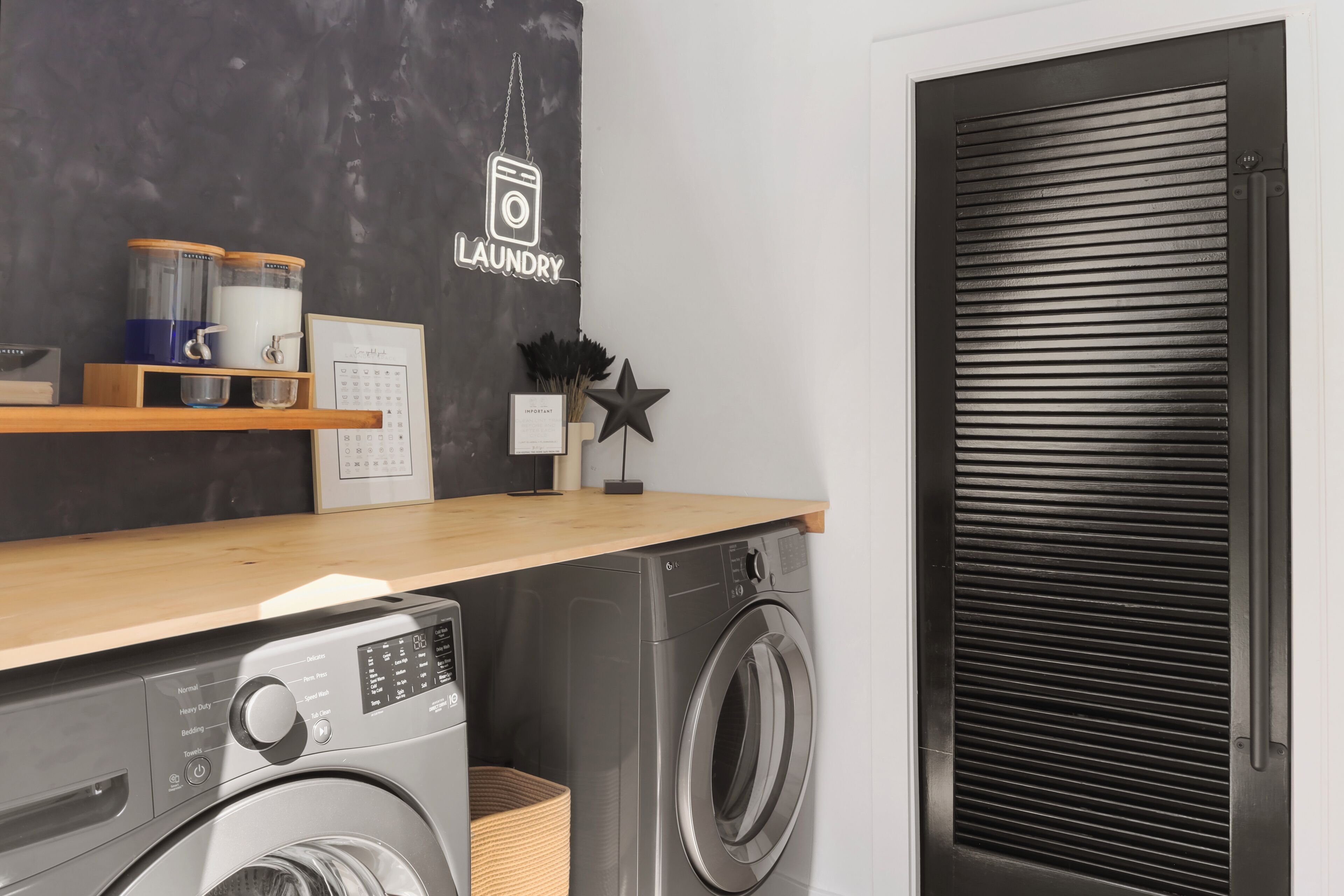 A laundry area with a washing machine, dryer, and a shelf with storage containers.