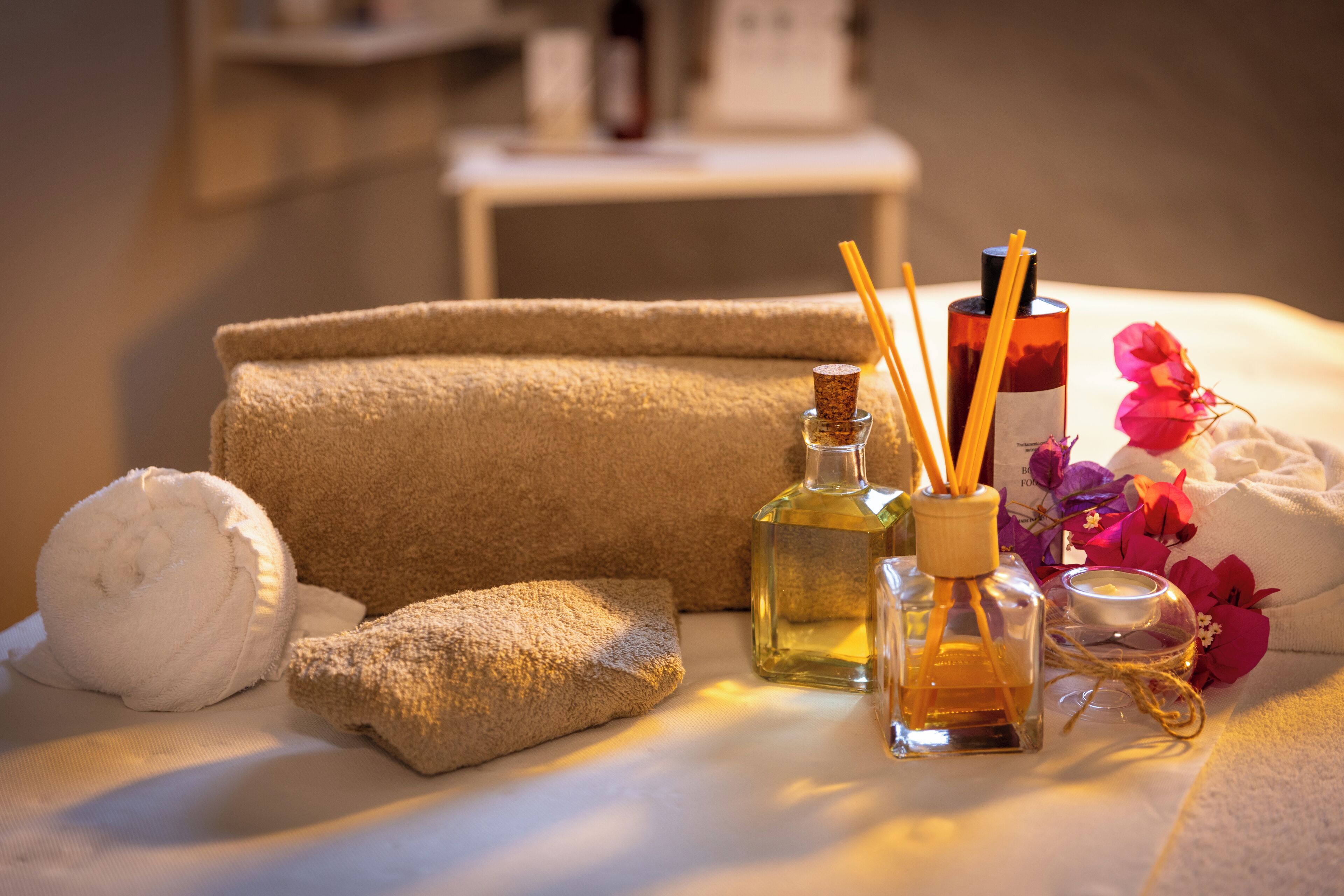 A neatly arranged bathroom with towels, a bottle of liquid soap, and a small container, suggesting a focus on hygiene and relaxation.