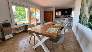Ein Essbereich mit Holztisch, Stühlen und Blick ins Freie.