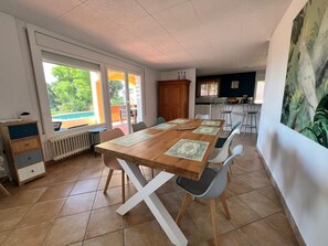 A dining area with a wooden table, chairs, and a view of the outdoors.