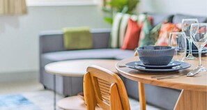 A dining area with a round table, a wooden chair, a dark bowl, and a glass on the table. - Family & Contractor Friendly Stay | WiFi, Parking (Farnborough)