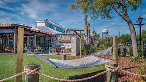 A brewery with outdoor seating, a hammock, and a water tower in the background.