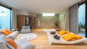 Relax in a spacious living area with a comfortable seating arrangement, a large coffee table, and a bathtub.
