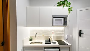 A compact kitchen with a microwave, sink, and dishwasher.