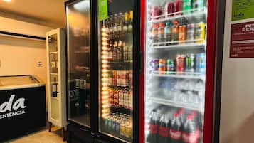 Three beverage vending machines, including a Coca-Cola cooler, in a commercial setting.
