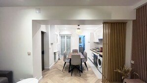 A modern kitchen with a dining area, a washing machine, and a wooden column. - Urban Flat 178 - Newly Renovated 2 BDR Flat in Paris (Paris)