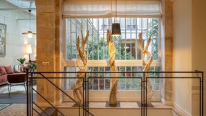A spacious living area with a large window, a staircase, and modern decor. - L'Atelier des Arts in Paris (Paris)