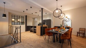 A modern dining area with a herringbone floor, wooden furniture, and pendant lighting. - L'Atelier des Arts in Paris (Paris)