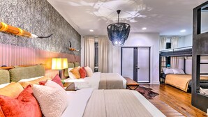 Une chambre d’hôtel avec deux lits, un grand lustre, un mur décoré de motifs et une vue sur l’extérieur.