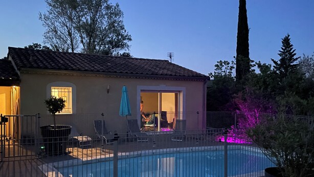 Ein Haus mit Swimmingpool, Terrasse und Garten.