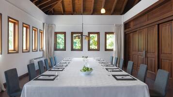 Une salle de conférence avec une longue table, des chaises et un plafond en bois.