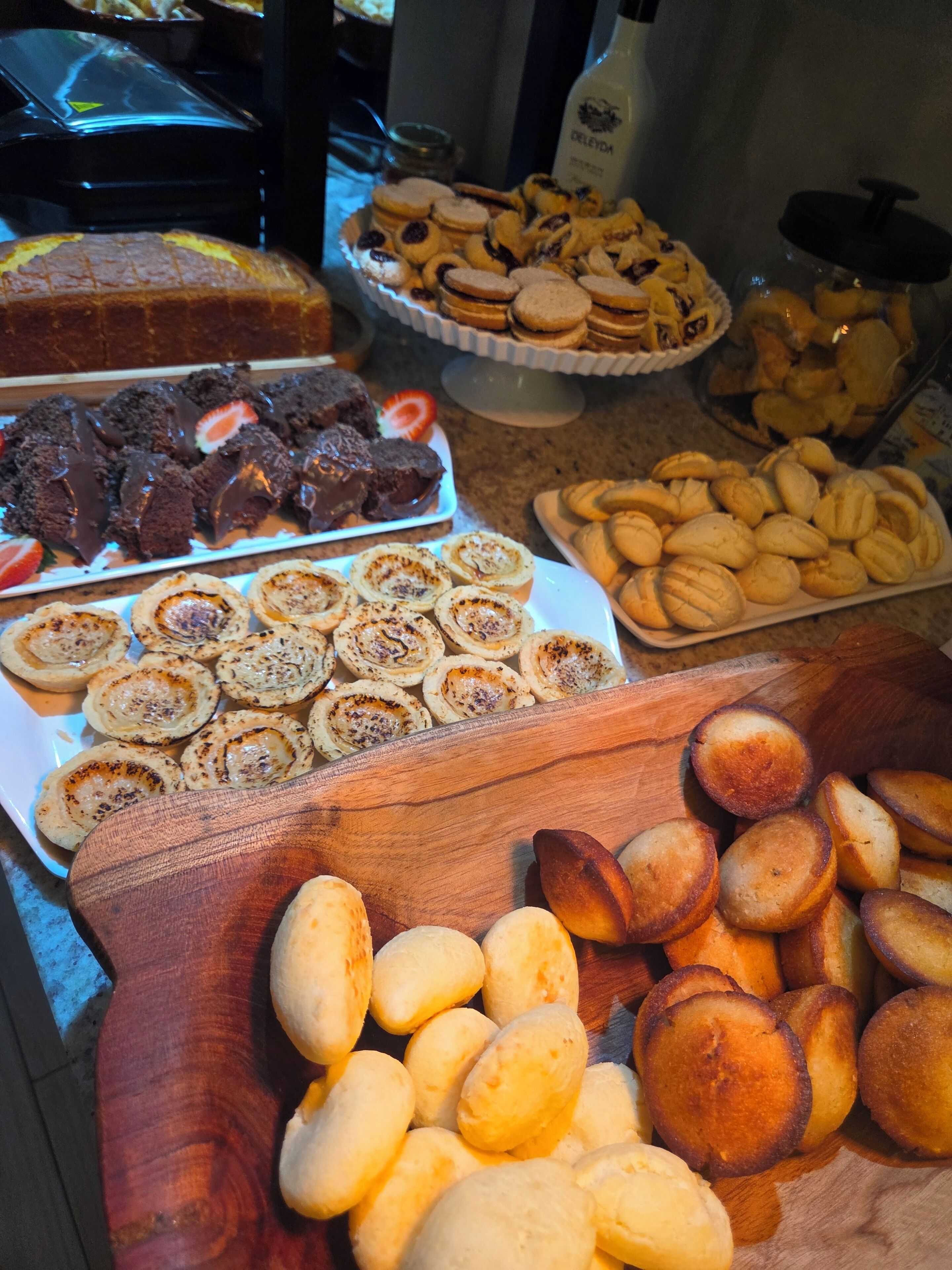 Diversos produtos de panificação expostos, como biscoitos, doces e pão.