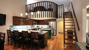 Una cocina moderna con una isla central, armarios de madera y un microondas integrado.