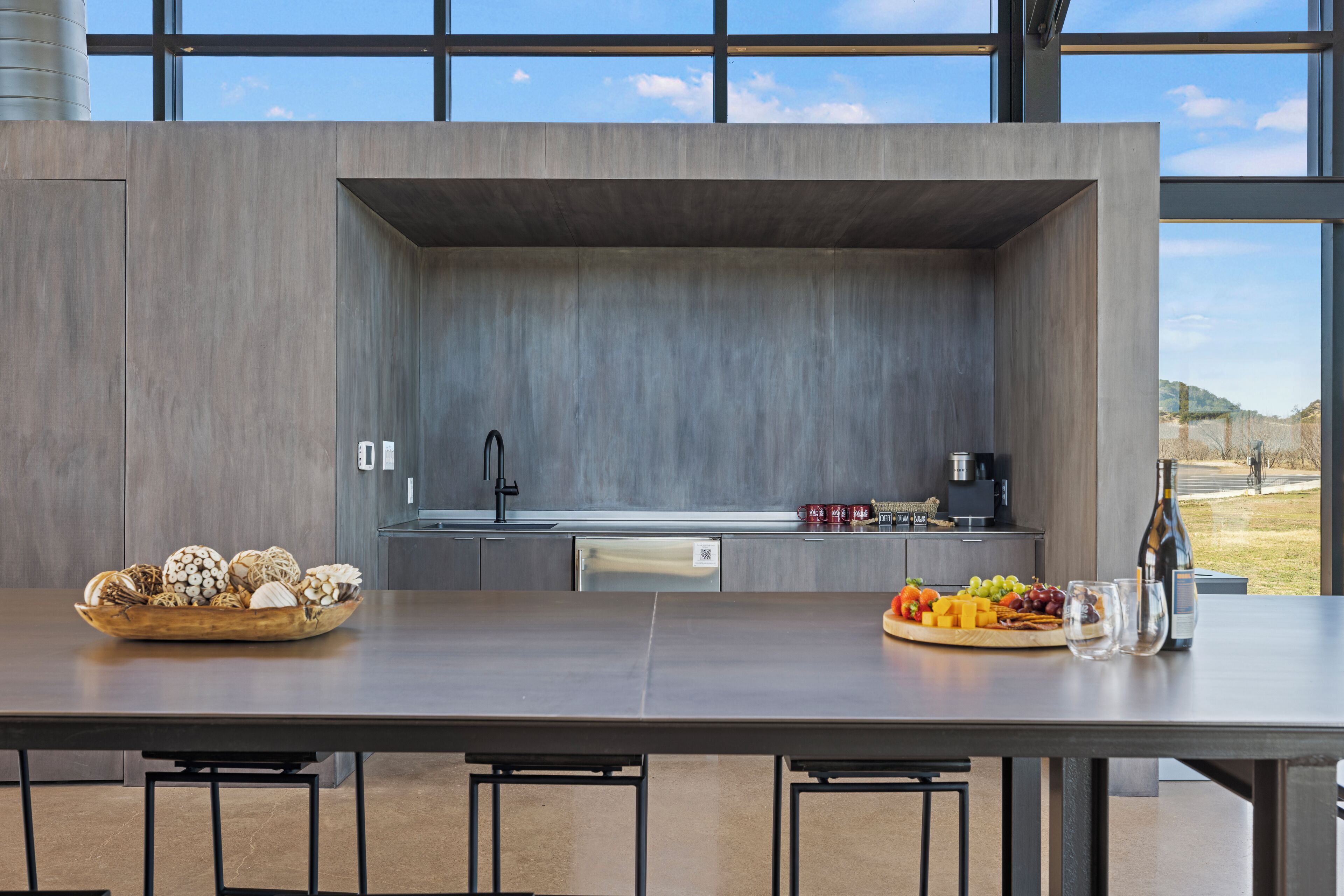 A modern kitchen with a large island, built-in appliances, and a view of the outdoors.