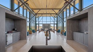 A modern kitchen with a central island, large windows, and a view of the outdoors. - SKYE Texas Hill Country Resort  (Fredericksburg)