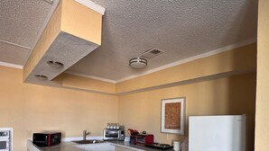 A compact kitchen with a microwave, toaster, and refrigerator. - CMI Hotel 1935 Myrtle Beach SC (Myrtle Beach)