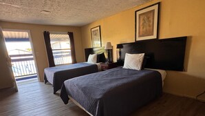 A hotel room with two beds, a balcony, and a framed picture on the wall. - CMI Hotel 1935 Myrtle Beach SC (Myrtle Beach)
