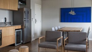 Une cuisine moderne dotée d’un réfrigérateur encastré, de meubles en bois et d’un coin repas avec une table et deux chaises.