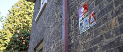 A brick building with a security camera and a poster on the wall.