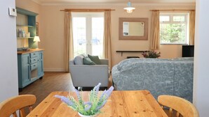 Une pièce chaleureuse avec une table à manger en bois, un canapé et un lit.