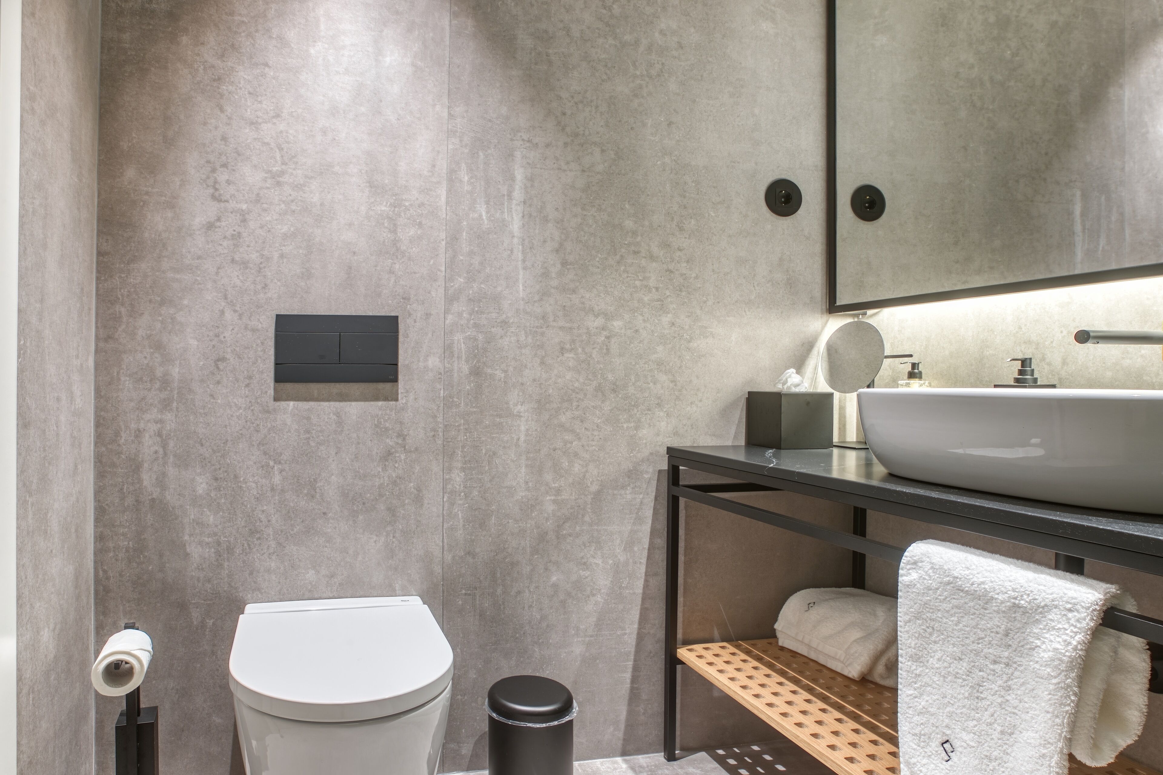 A modern bathroom with a toilet, bidet, and sink.