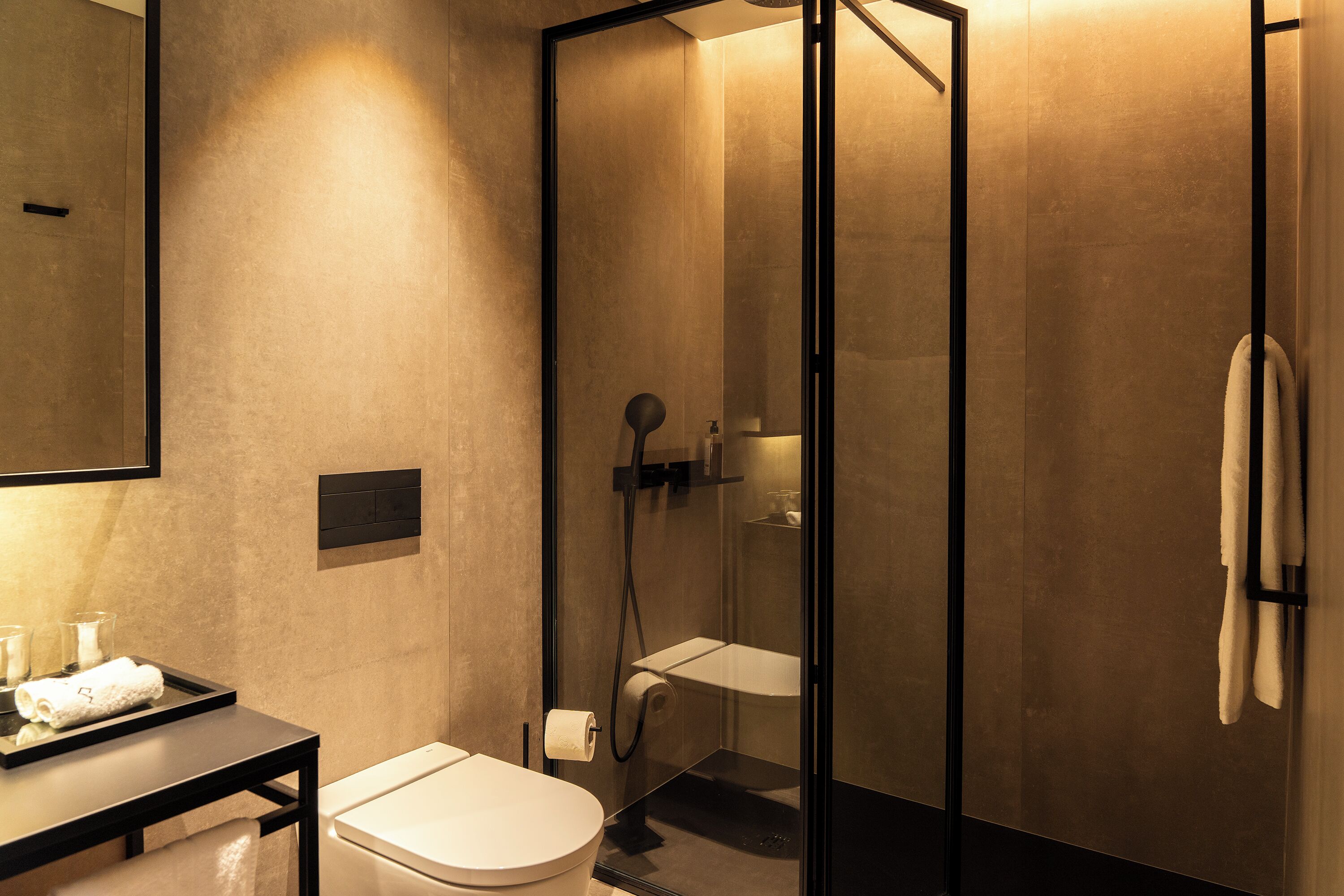 A modern bathroom with a toilet, sink, and glass-enclosed shower.