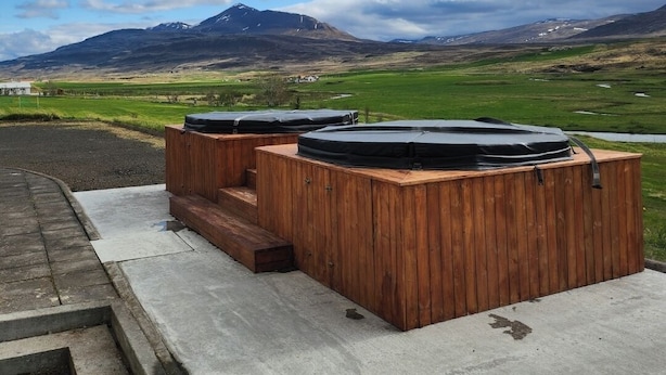 Un espace extérieur aménagé avec des sièges en bois, offrant une vue sur un paysage montagneux.