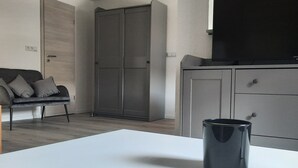 Eine moderne Küche mit einer weißen Arbeitsplatte, einer schwarzen Tasse und einem grauen Schrank.