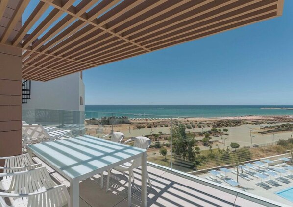 Un balcon avec vue sur la plage et l’océan.