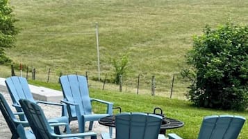 Een terras met zitplaatsen en uitzicht op een grasveld.