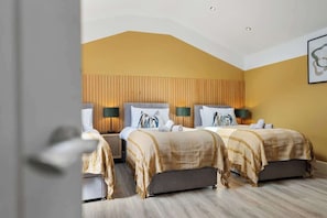 Une chambre d’hôtel avec deux lits, une tête de lit en bois et une œuvre d’art accrochée au mur.
