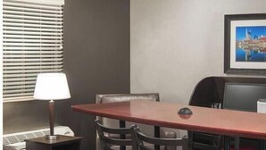 A conference room with a long table, multiple chairs, a lamp, a heater, and a framed picture on the wall. - Cozy 1-bedroom hotel in delightful Huntersville up to 2 people (Huntersville)