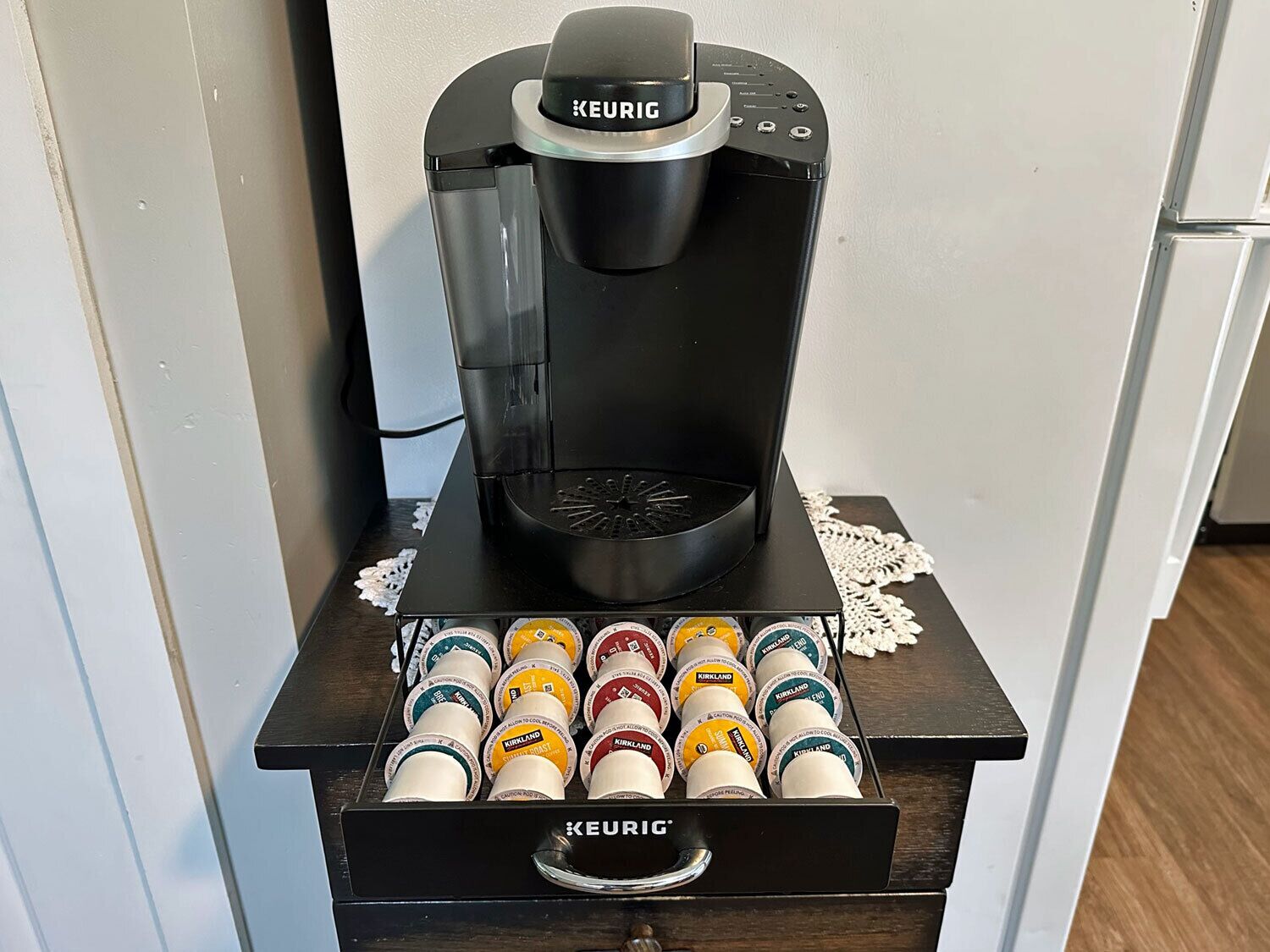 A Keurig coffee machine with a coffee pod holder below it.