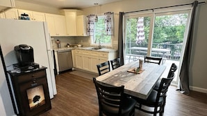 Una cocina moderna con comedor, que incluye cafetera, armarios y vistas al exterior.