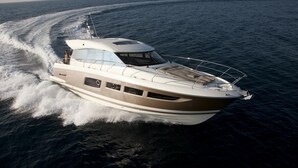 A luxury yacht with a spacious deck, a covered upper deck, and a wake behind it. - Luxurious 55-Foot Yacht with Captain & First Mate (Sarasota)