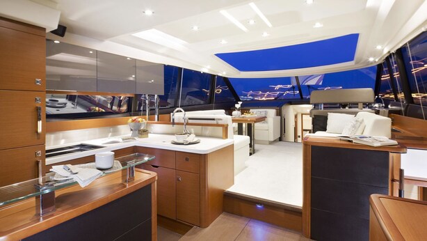 A modern yacht interior with a galley, seating area, and a view of the sea. - Luxurious 55-Foot Yacht with Captain & First Mate (Sarasota)