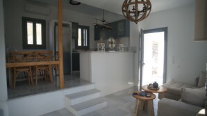 Un ambiente moderno con zona pranzo, cucina e soggiorno.