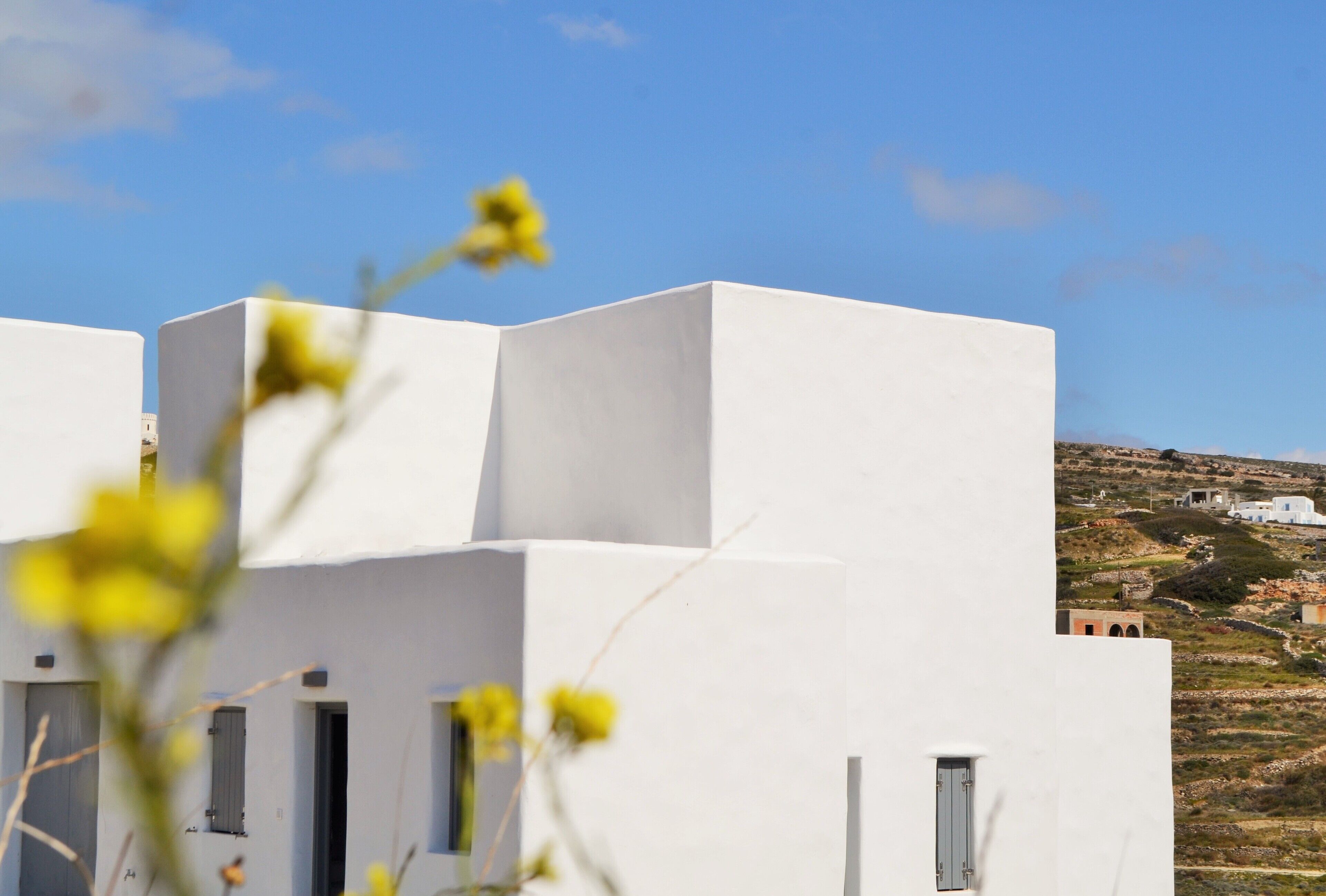 Un bâtiment blanc avec un toit plat et une petite fenêtre.